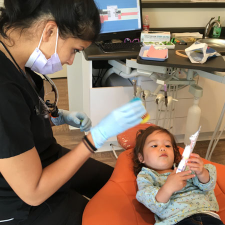 girl looking at tooth brush in chair